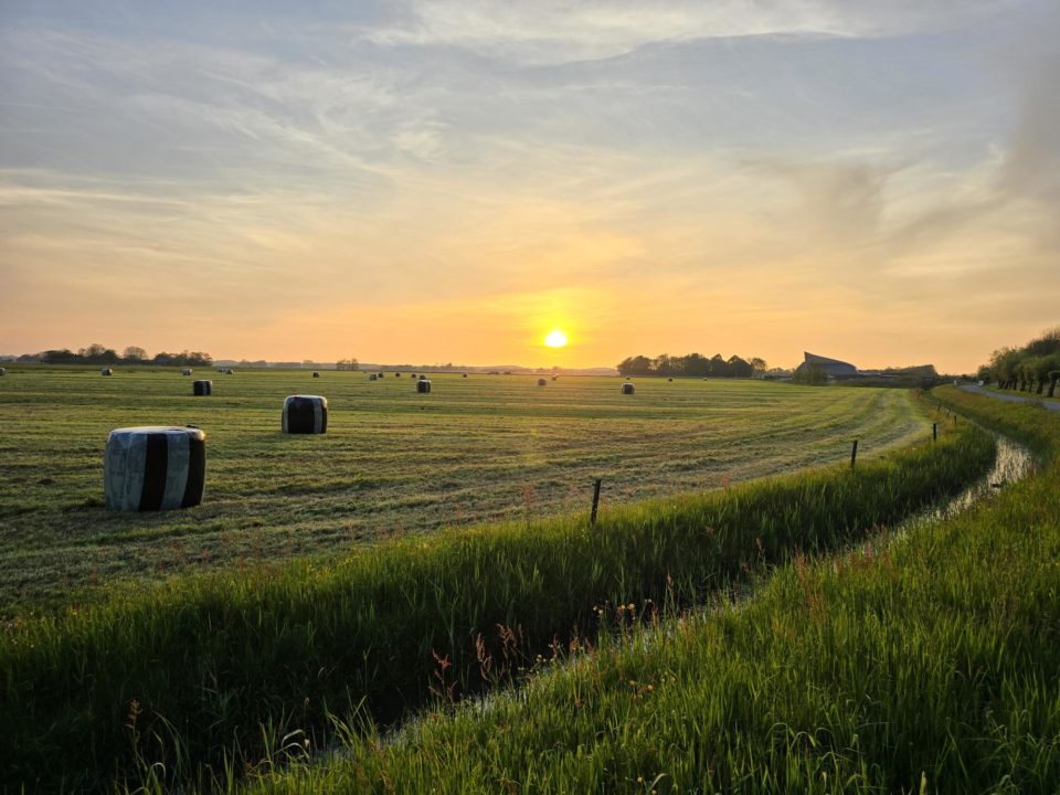 grasbalen ondergaande zon